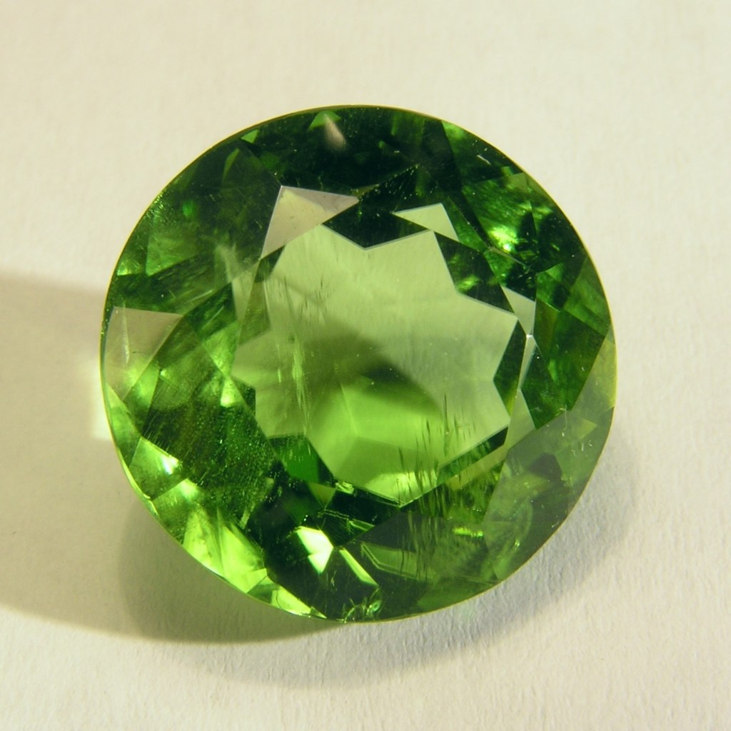 round faceted peridot gemstone